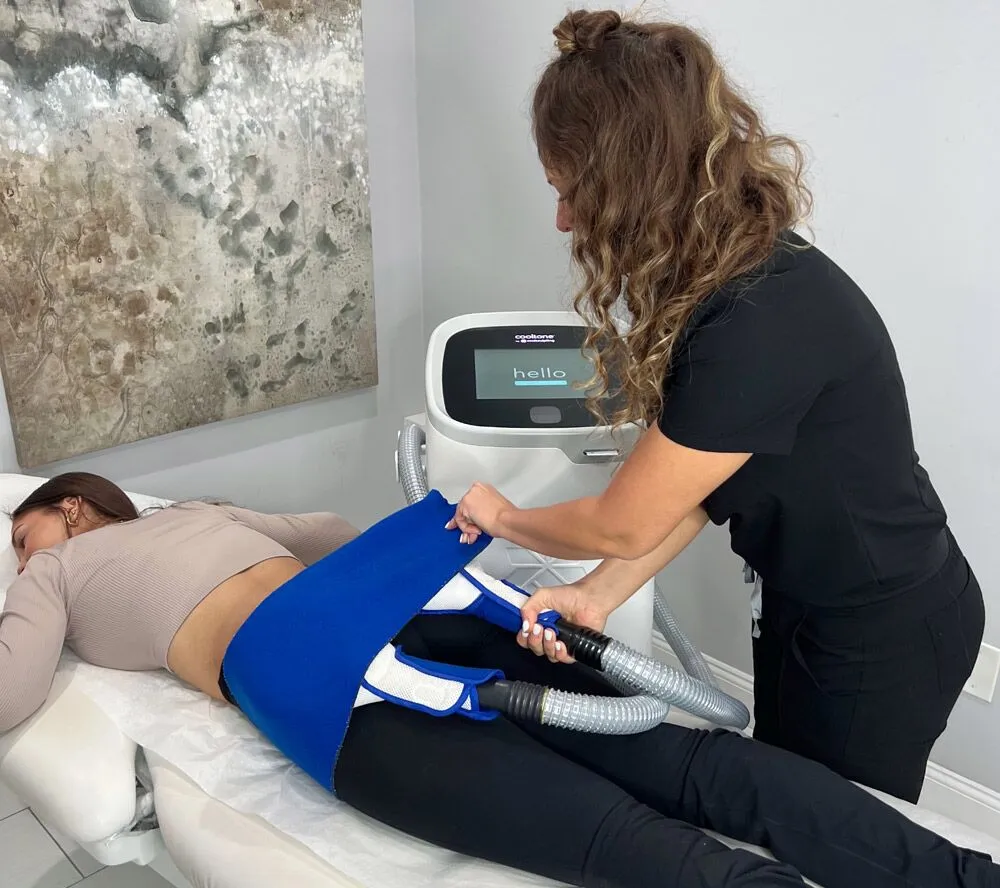 Photo of a CoolTone body sculpting treatment at Liv Aesthetics LLC in Thornwood, NY. A client lies relaxed as applicators are positioned on their abdomen, showcasing a non-invasive procedure that tones and strengthens muscles using magnetic muscle stimulation.
